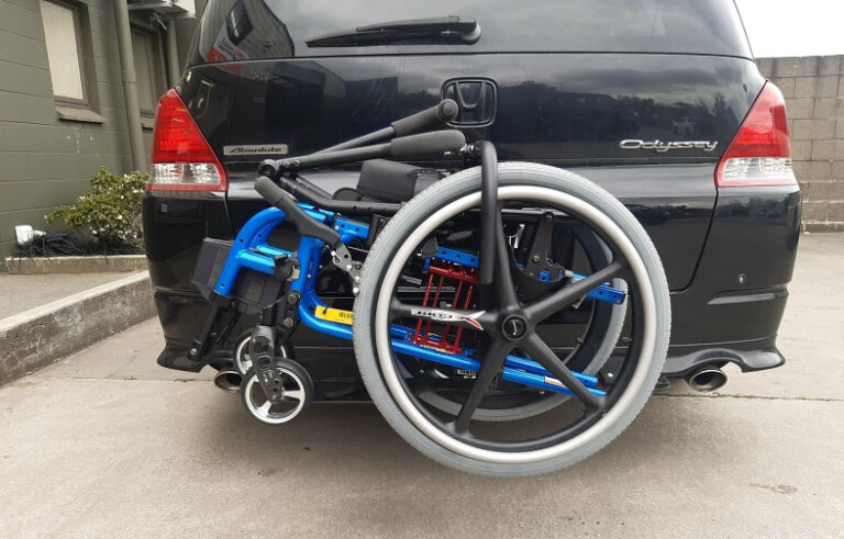 A photo of a wheelchair carrier installed on the back of a car