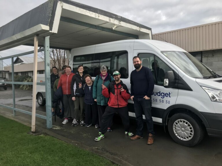 A group photo taken in front of a van