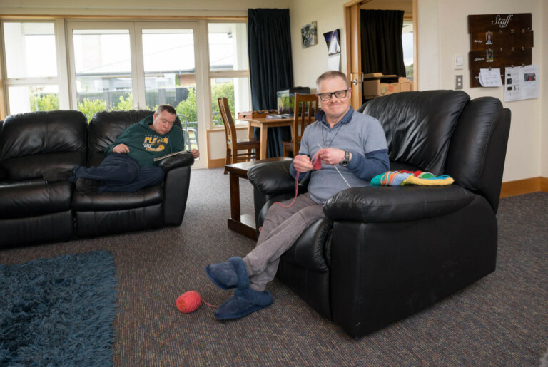 a-person-sitting-in-a-chair-knitting__ScaleMaxWidthWzEwMDBd